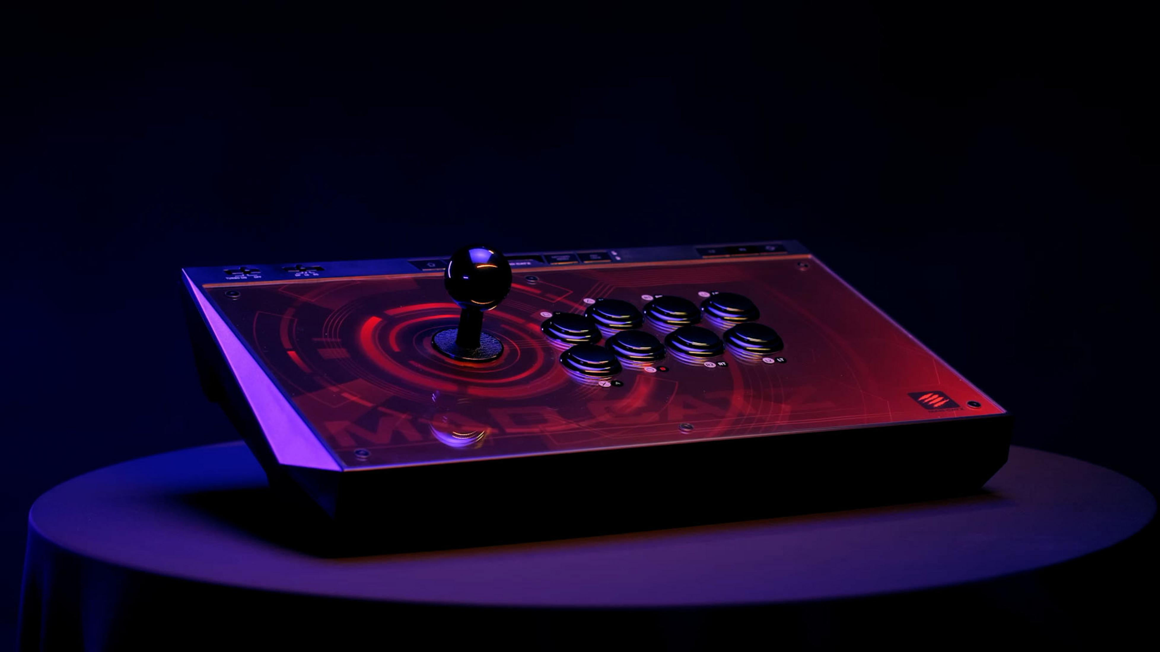 Joystick da gioco su un tavolo, con parte superiore nera e dettagli di design rossi.