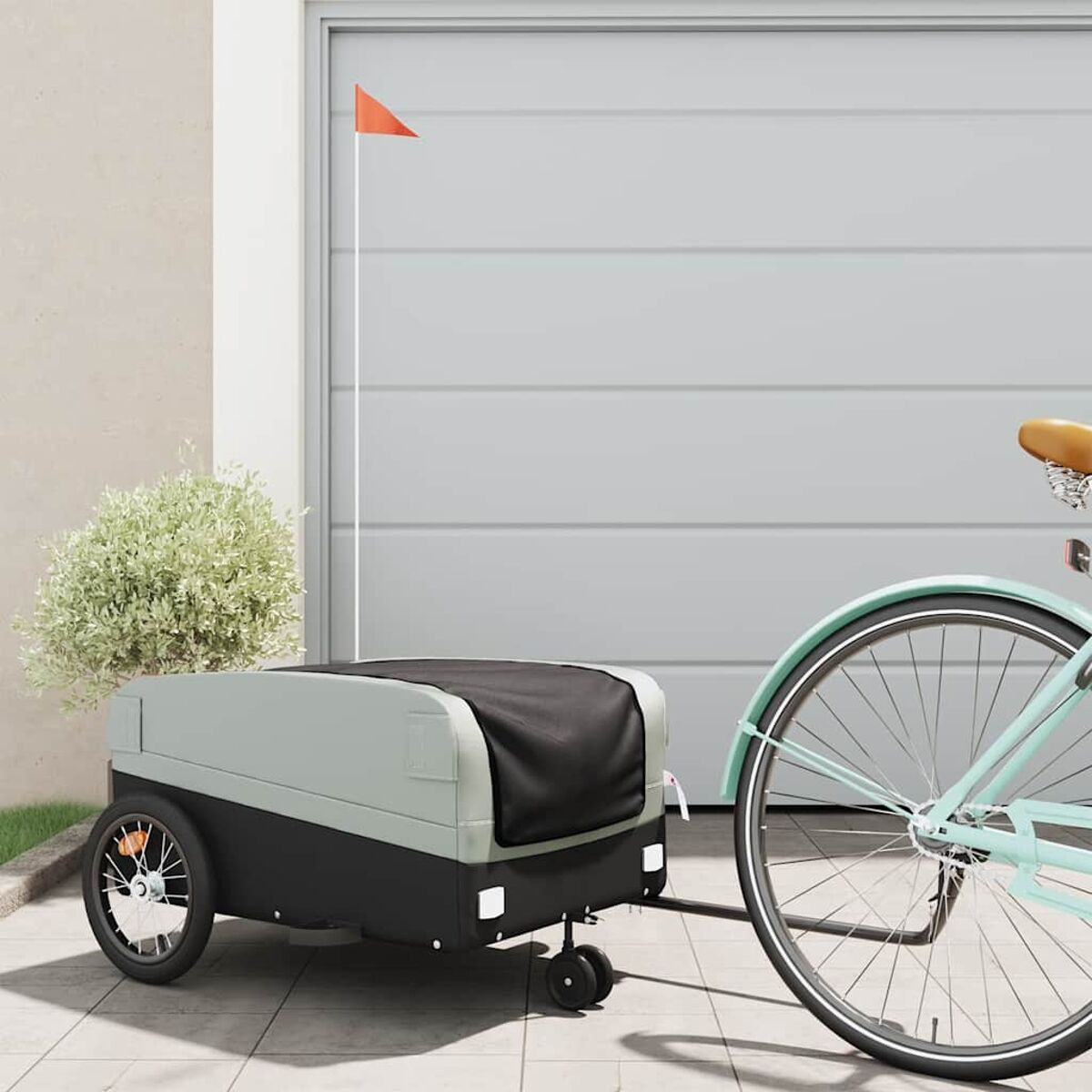 Fahrradanhänger mit orangefarbener Fahne. Schwarzer und grauer Anhänger. Hellgrünes Fahrrad.