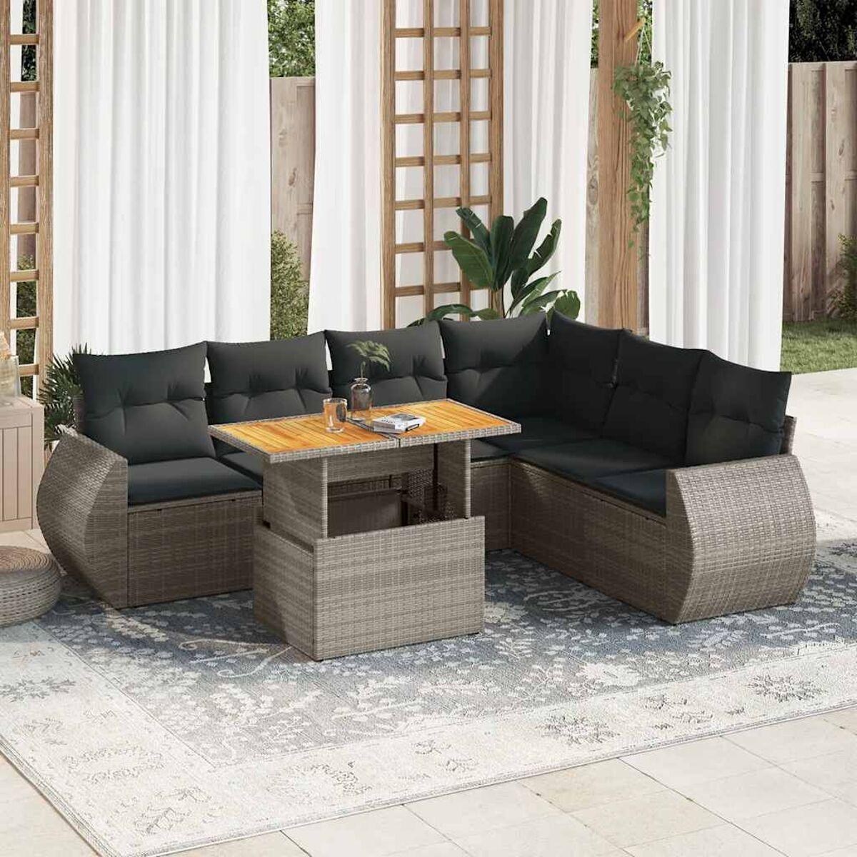 Outdoor-Sofagarnitur mit grauen Kissen und einem Hubtisch. Auf einem gemusterten Teppich. Neutraler Hintergrund.
