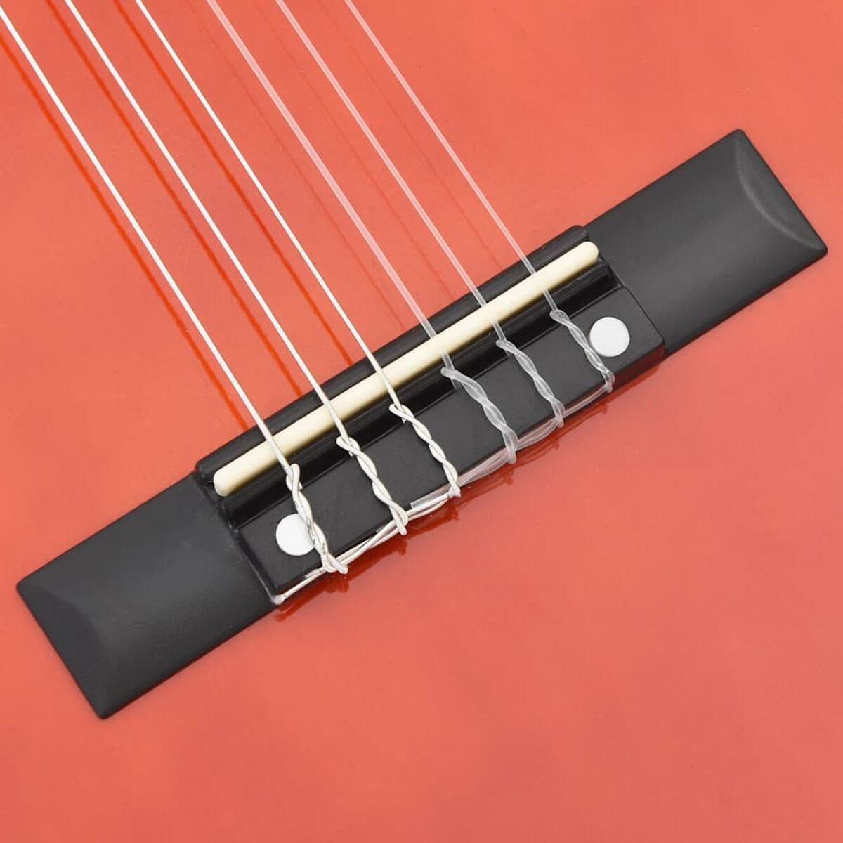 Nahaufnahme einer roten Gitarrenbrücke mit weißen Saiten.