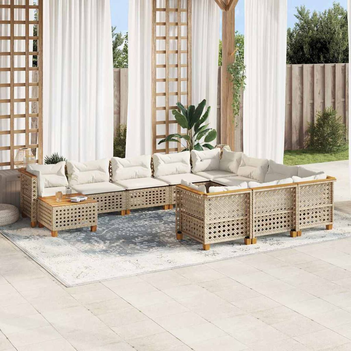 Divano componibile in rattan da esterno con cuscini e un tavolino in legno su un tappeto.