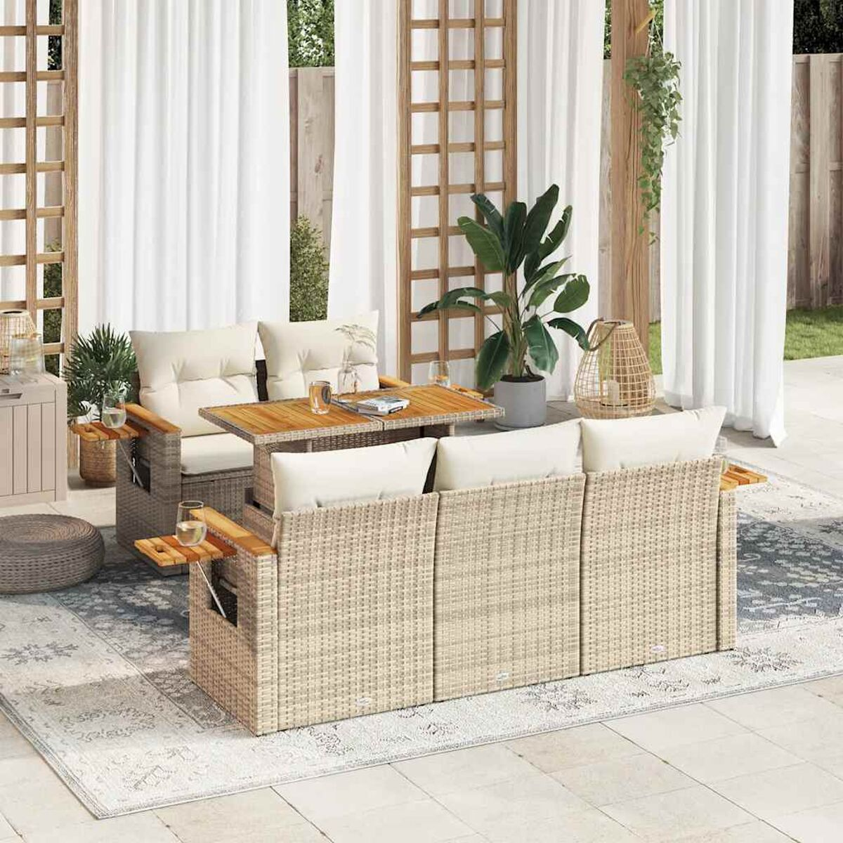 Outdoor-Sofagarnitur mit Tisch, Gläsern und Kissen in sonniger Umgebung.