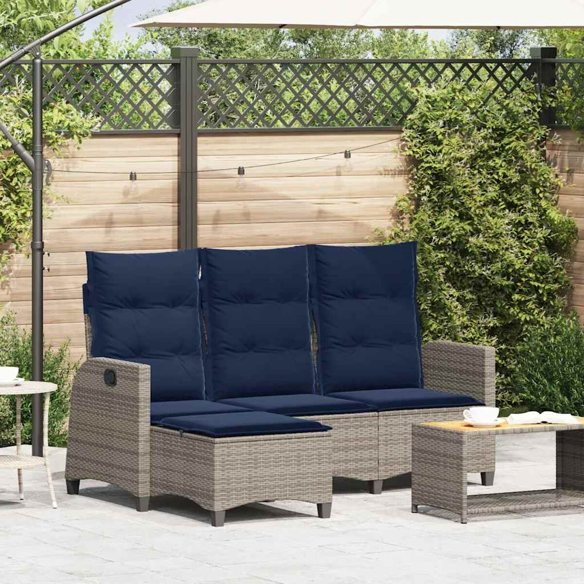 Gartenmöbel-Set mit blauen Kissen, Dreisitzer-Sofa, Fußhocker und kleinem Tisch.