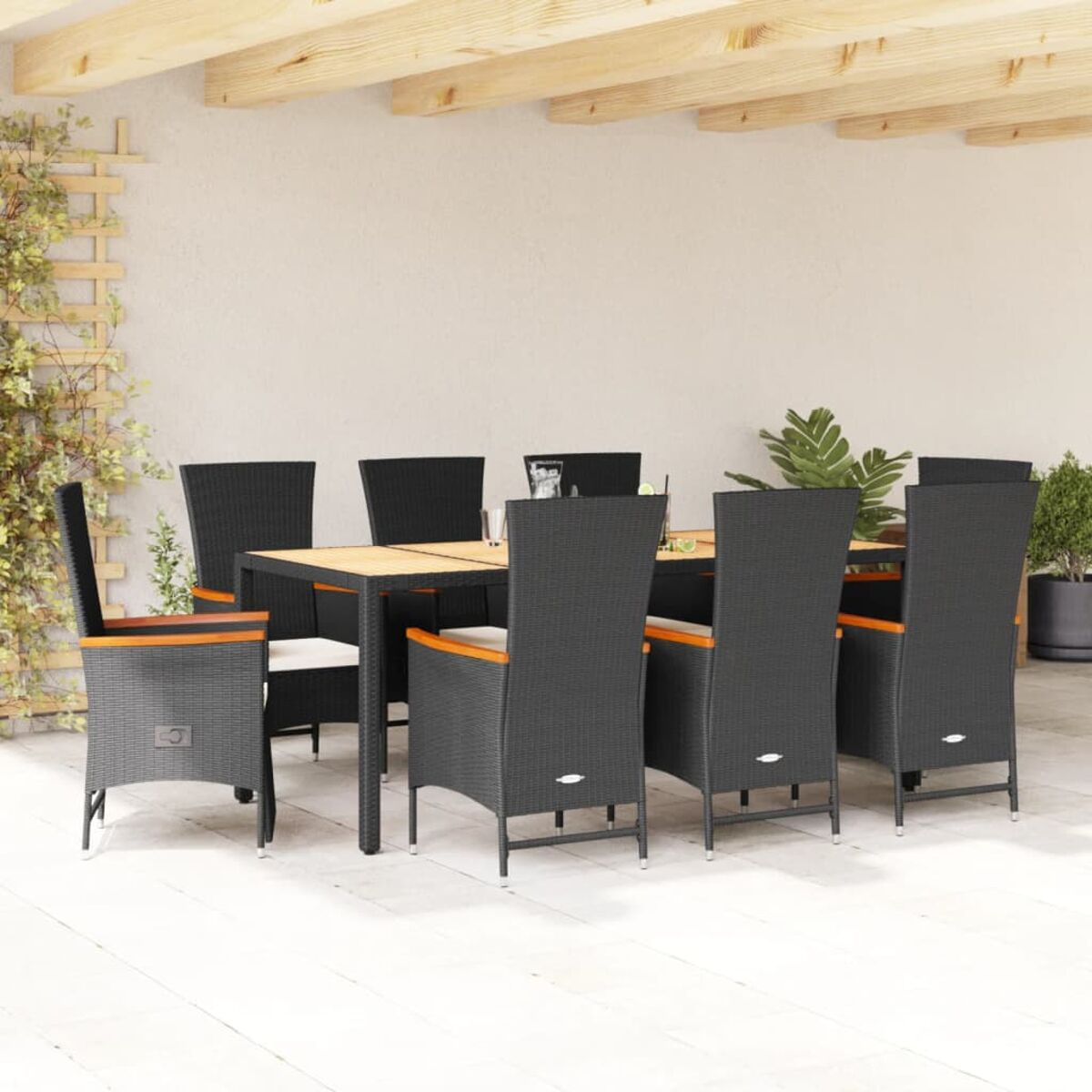 Set da pranzo per esterni con sedie nere, tavolo in legno e sfondo parete chiaro.