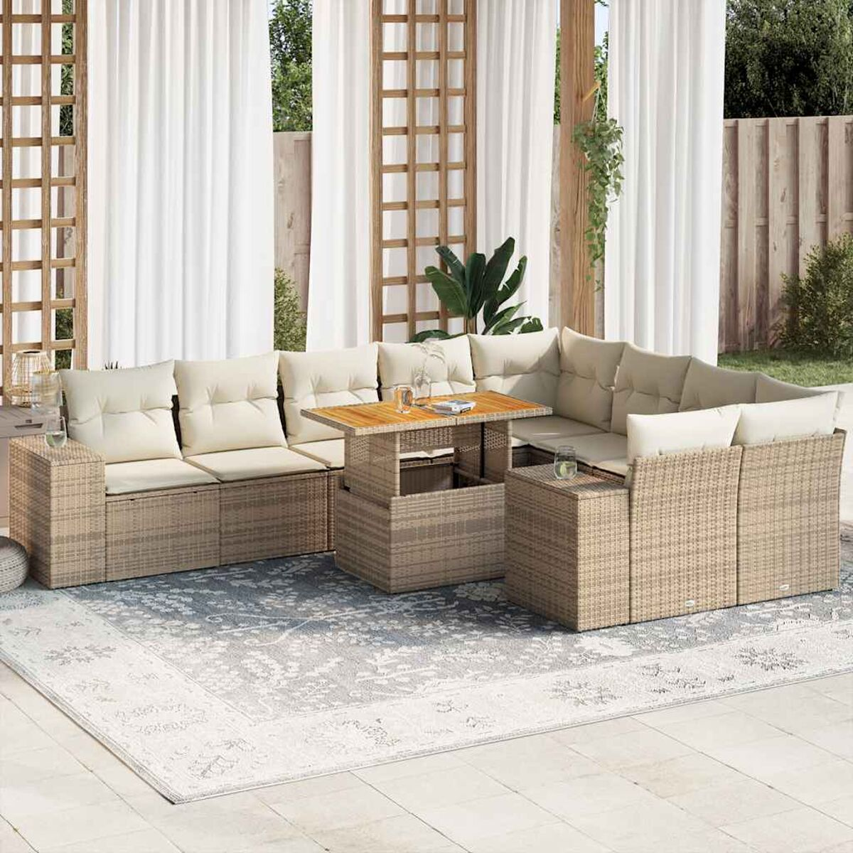 Divano componibile da esterno in rattan con tavolo, cuscini bianchi e un tappeto con tende.