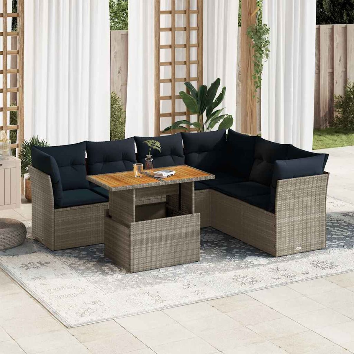 Set living esterno con tavolo sollevabile e due divani componibili. Cuscini neri e un tappeto.