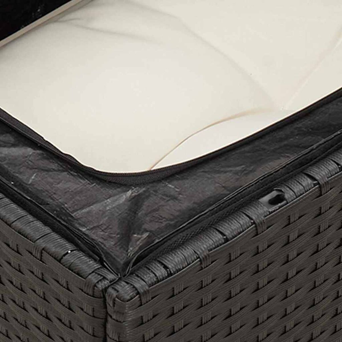 Detail eines schwarzen und braunen gewebten Outdoor-Sofas. Schwarze Abdeckung bedeckt das cremefarbene Kissen.