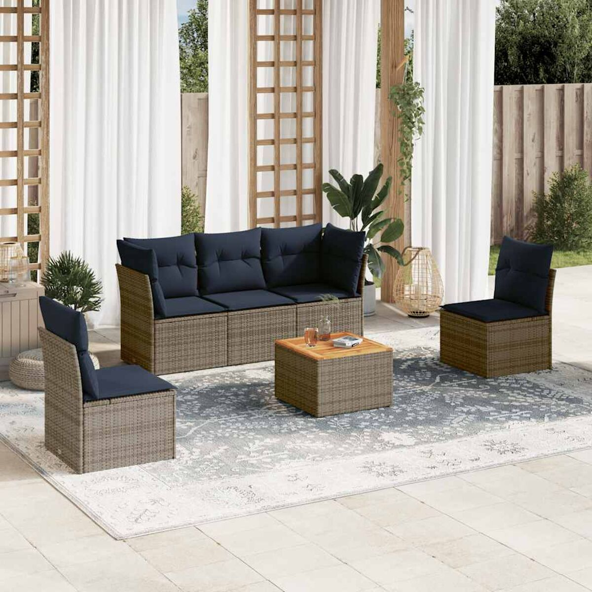 Set di mobili da esterno: divano, sedie e tavolo, tutto in vimini marrone con cuscini blu.