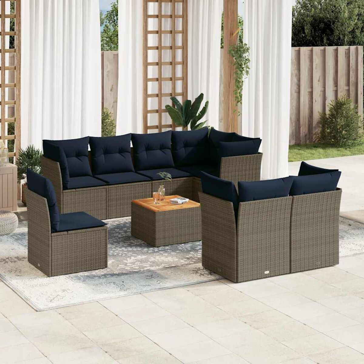 Un set da esterno in rattan con divano, due sedie e un tavolo, tutti con cuscini blu.