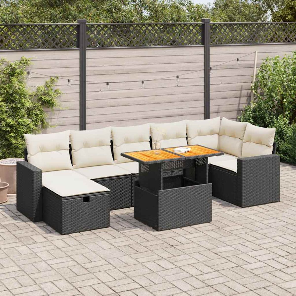 Garten-Eckgarnitur. Schwarzes Korbgeflecht, beige Kissen, Holztisch. Garten.