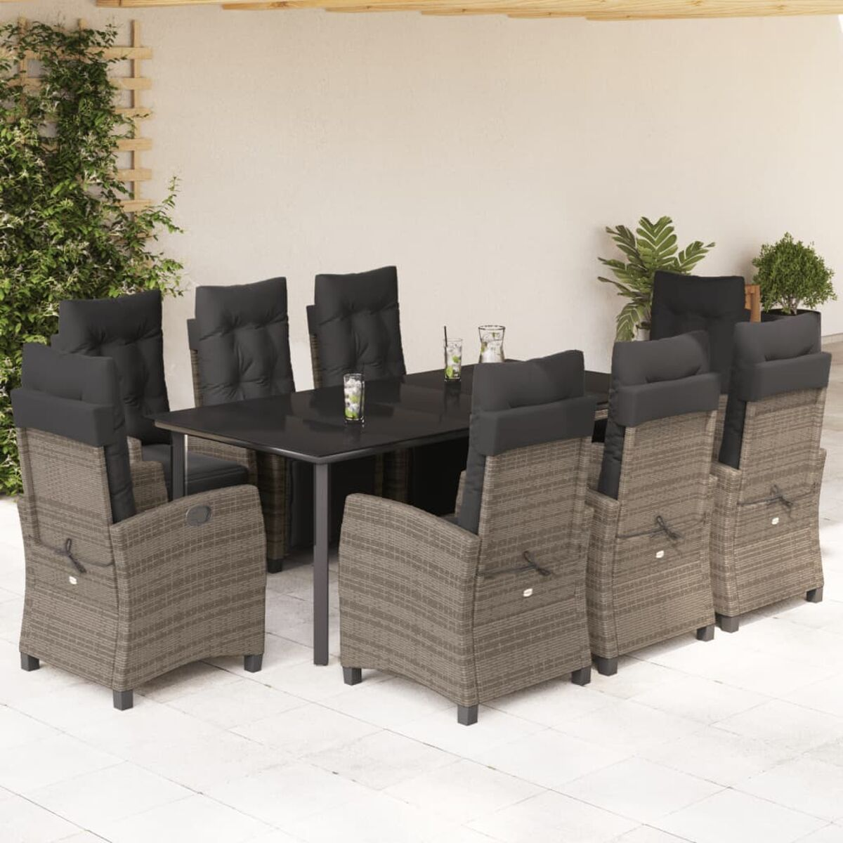 Essgruppe im Freien mit einem schwarzen Tisch und Stühlen. Stühle im Rattan-Stil.