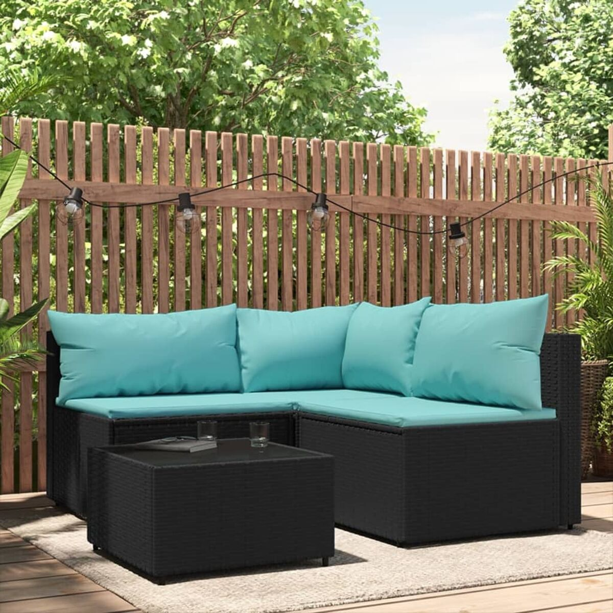 Schwarzes Rattan-Ecksofa-Set mit türkisfarbenen Kissen, auf einer Terrasse, mit kleinem Tisch.