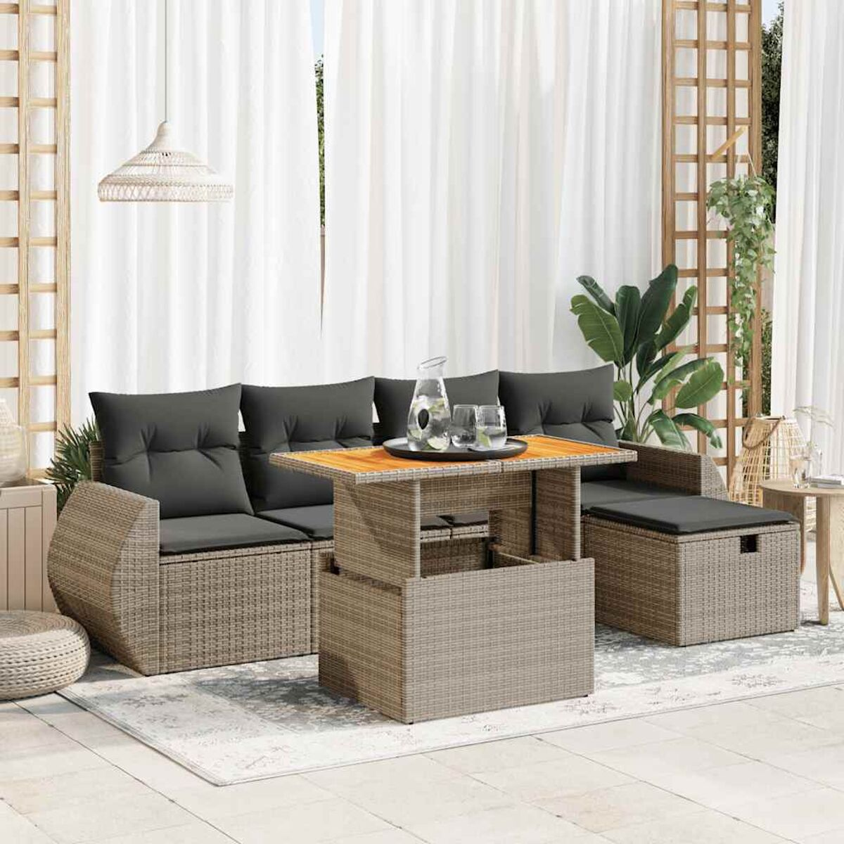 Gartenmöbel-Set im Rattan-Stil. Enthält Sofa, Tisch und Stauraum. Szene mit weißen Vorhängen.