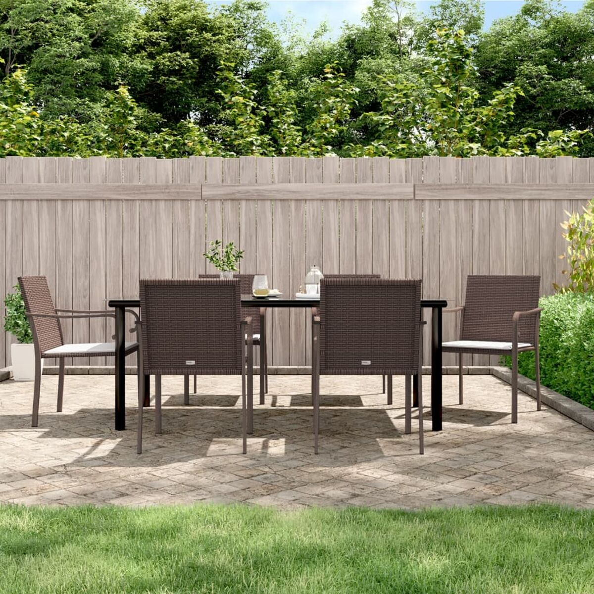 Essgruppe für den Außenbereich mit sechs Stühlen und einem Tisch auf einer gepflasterten Terrasse.