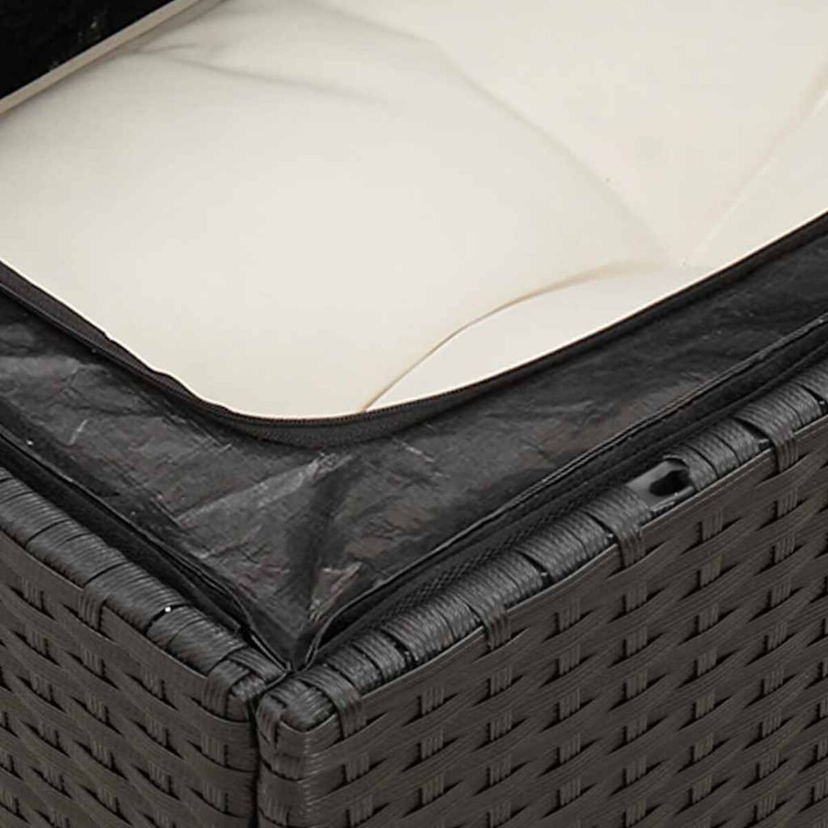 Nahaufnahme einer schwarzen Rattan-Sofaoberfläche mit einem weißen Kissen.