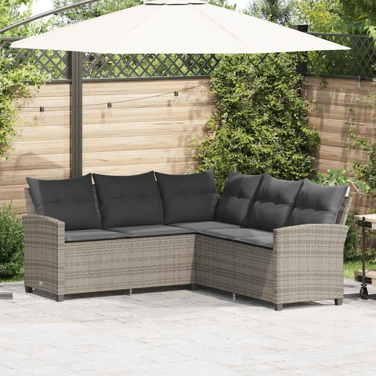 Ein Ecksofa mit grauen Kissen wird gezeigt, auf einer Terrasse aufgestellt.