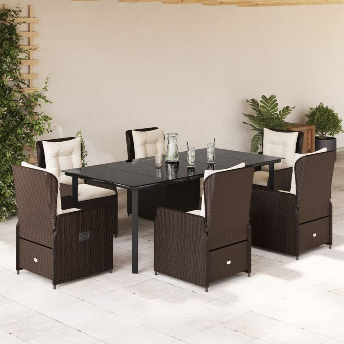 Ein Tisch und Stühle auf einer Terrasse. Die Stühle sind braun und haben weiße Kissen.