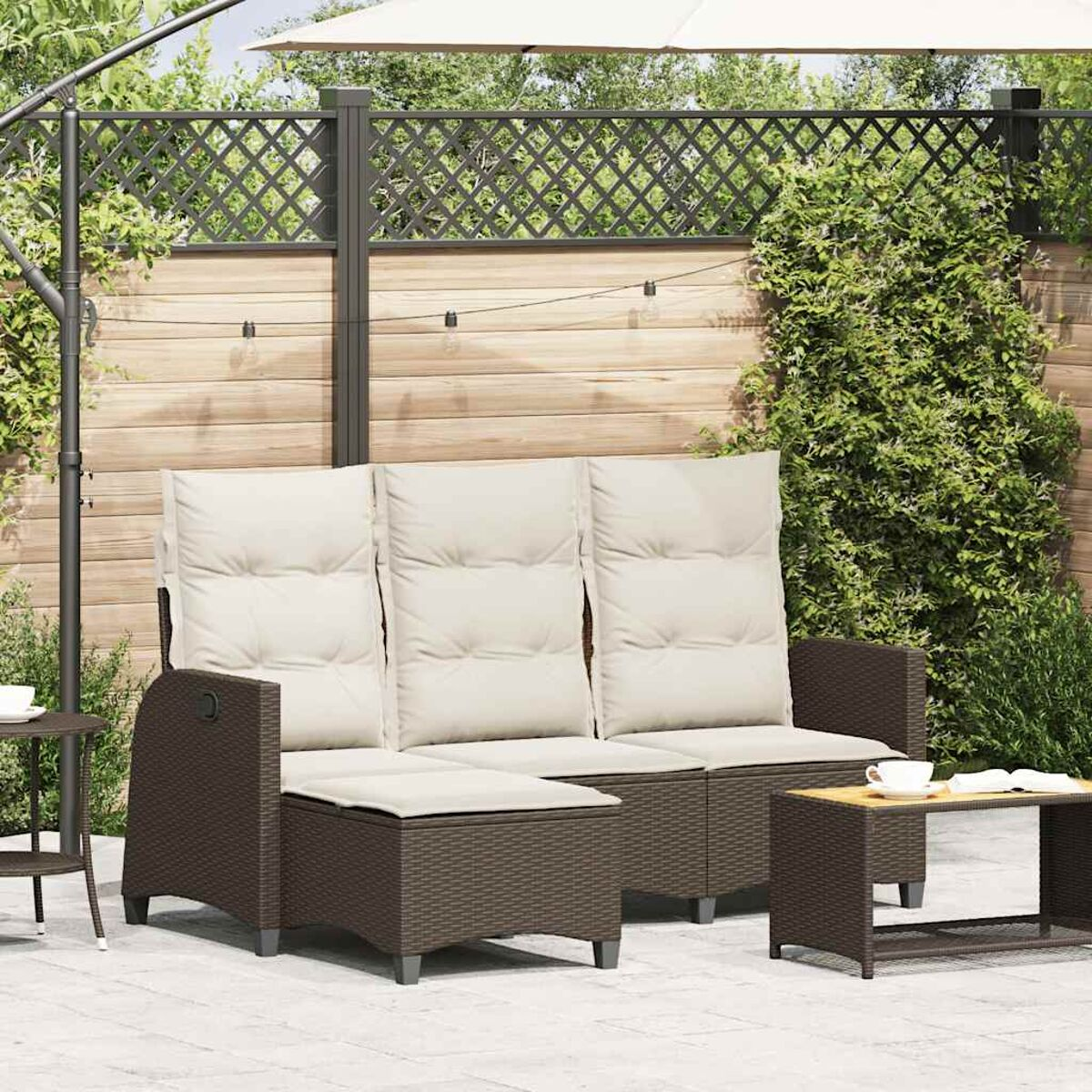 Garten-Korbsessel-Set mit Fußstütze und kleinem Tisch.