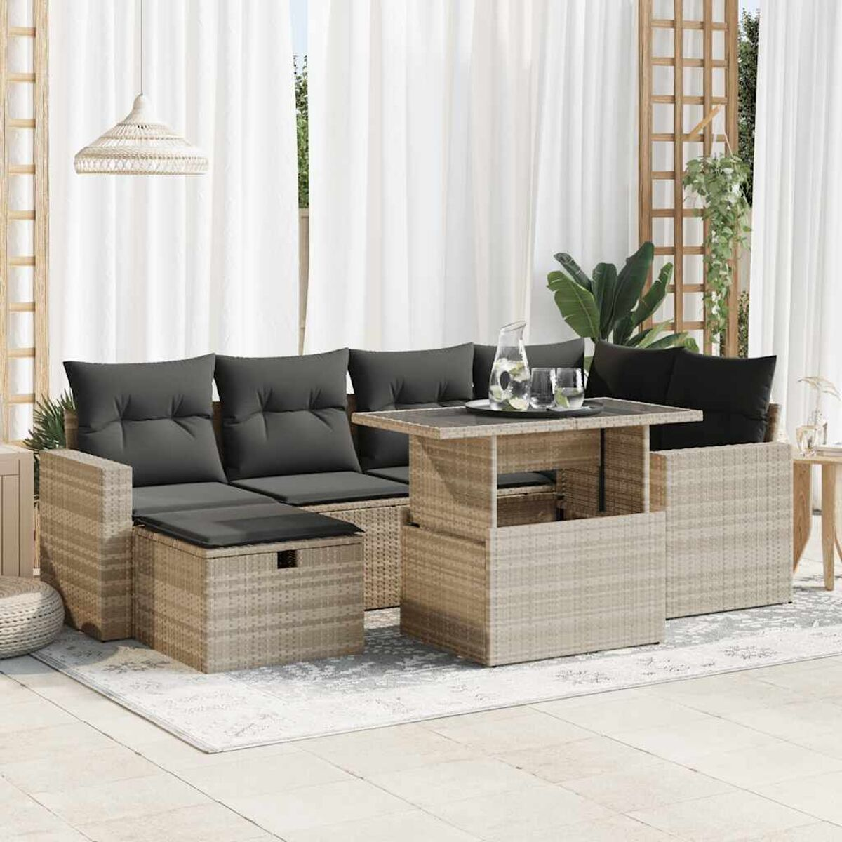 Ein modernes Sitzensemble für den Außenbereich mit einem Tisch. Es hat graue Kissen und eine helle Farbe.