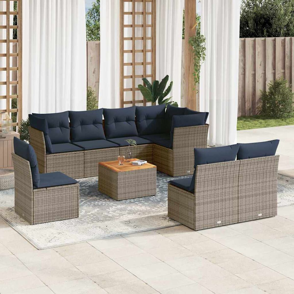 Set di mobili da patio all'aperto con divano angolare, sedie e tavolino, su un tappeto fantasia.
