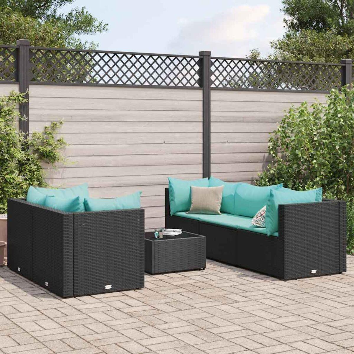 Set patio esterno con cuscini turchese, mobili neri e pavimentazione in mattoni.