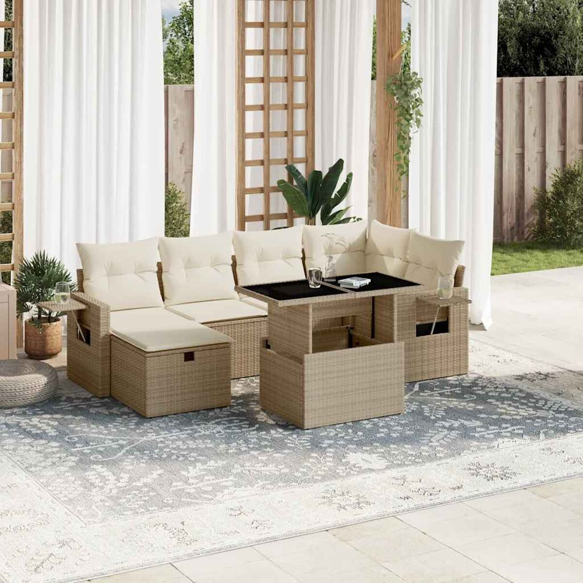 Divano angolare in vimini beige con tavolo sollevabile e tavolini, su un tappeto.