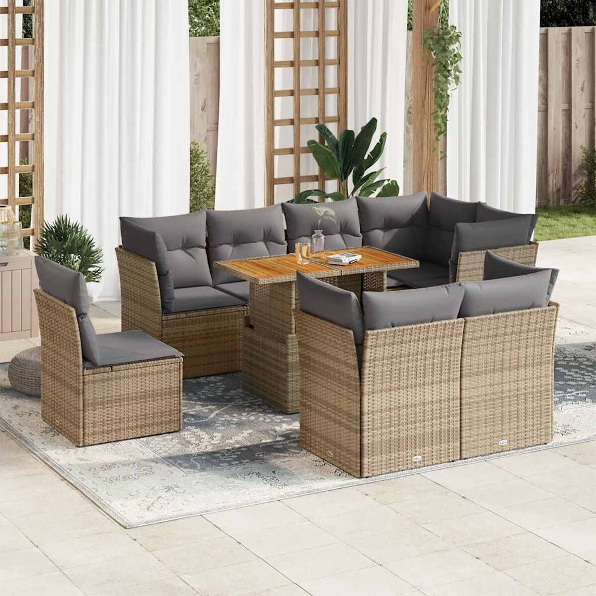 Un set in rattan da esterno con divano, tavolo e sedie. Un'ambientazione in giardino.