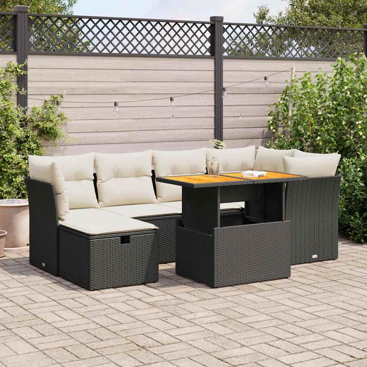 Gartenmöbel-Set mit Hebetisch, Kissen und dekorativen Pflanzen.
