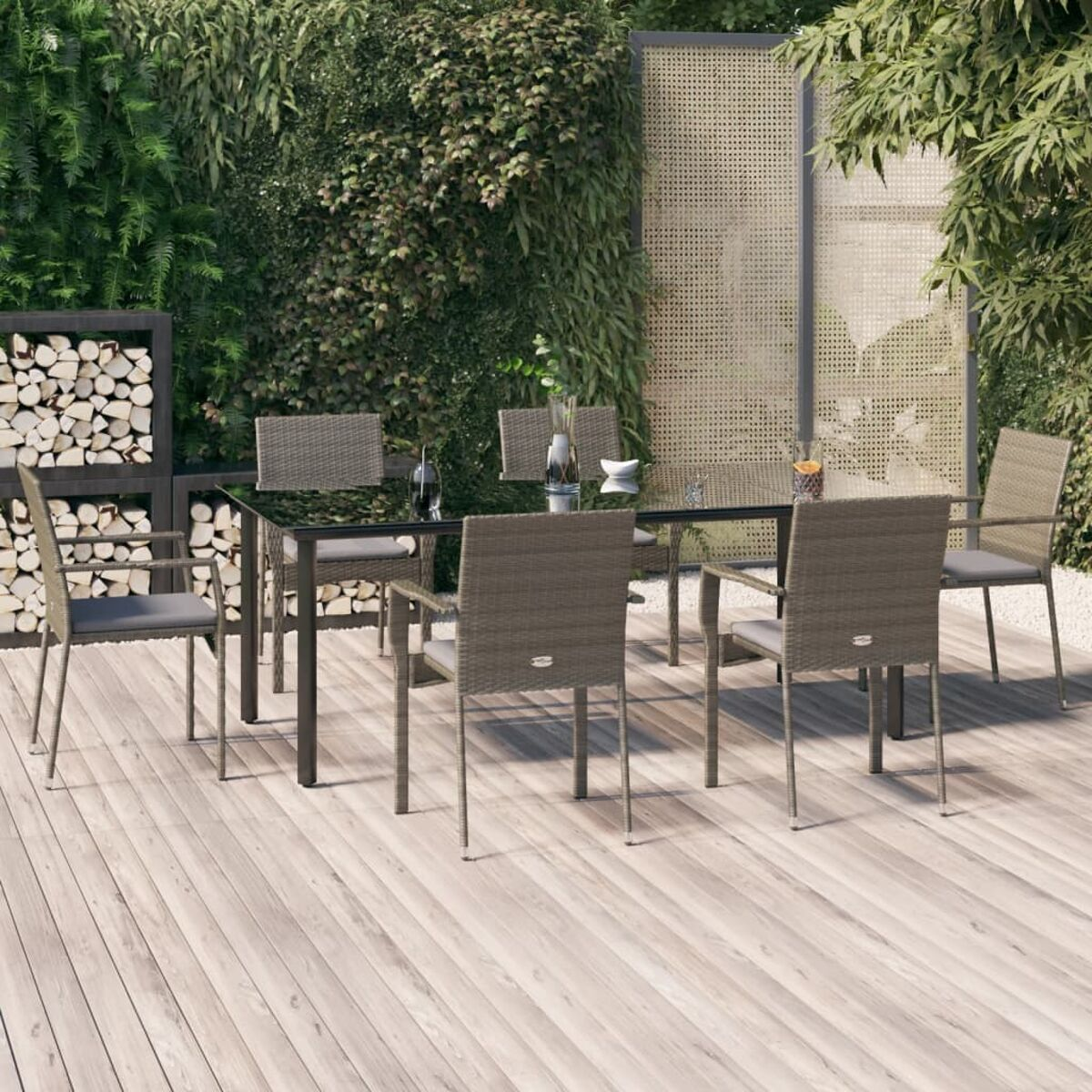 Essgruppe im Freien mit Glastisch, sechs Stühlen und Holzterrasse.