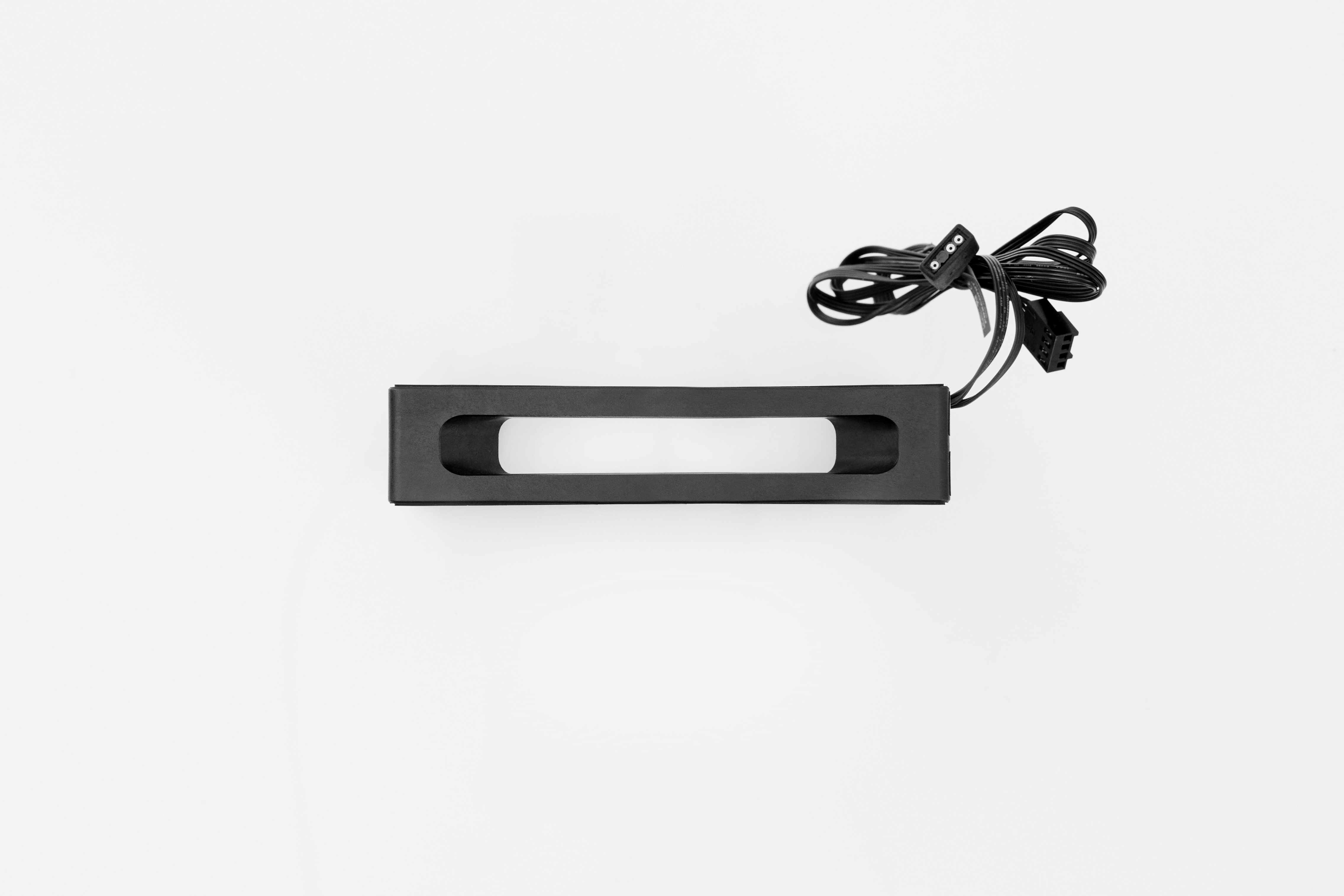 Zwarte, rechthoekige lamp. Het heeft een rechthoekige opening in het midden. Zwarte kabel met connector.