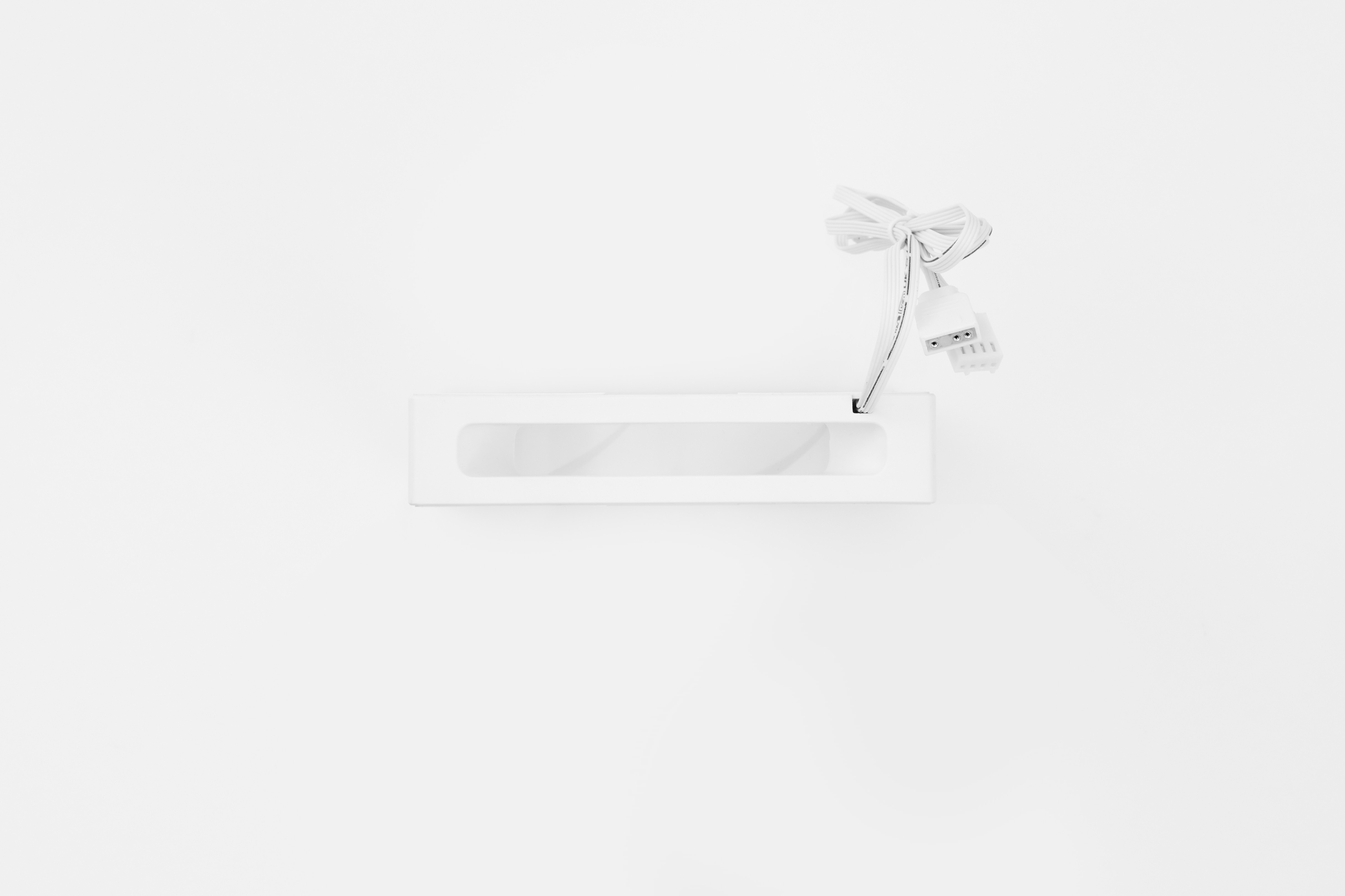 Witte, rechthoekige lamp. Het heeft een rechthoekige opening in het midden. Witte kabel met connector.