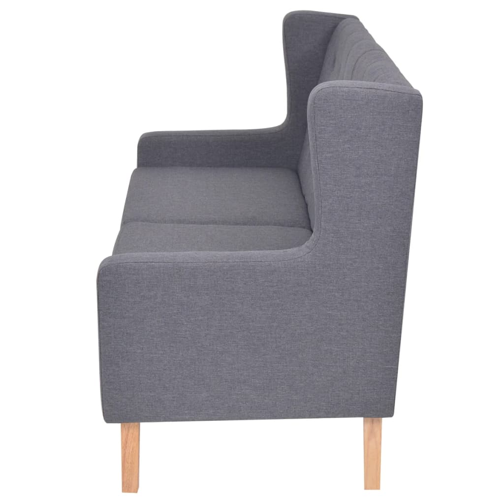 Ein graues Stoffsofa mit Holzbeinen, von der Seite betrachtet.