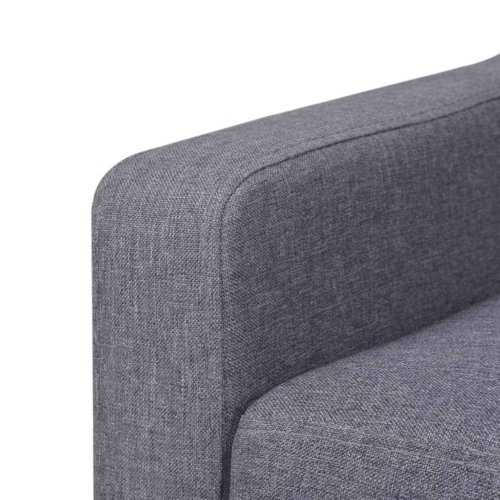 Nahaufnahme von grauem Stoff auf der Armlehne eines Sofas.