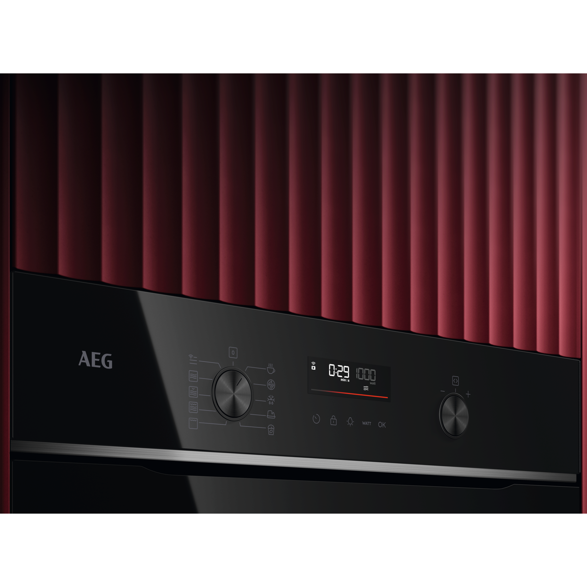 Primo piano del pannello di controllo di un forno AEG nero. Display che mostra l'ora. Sfondo rosso.