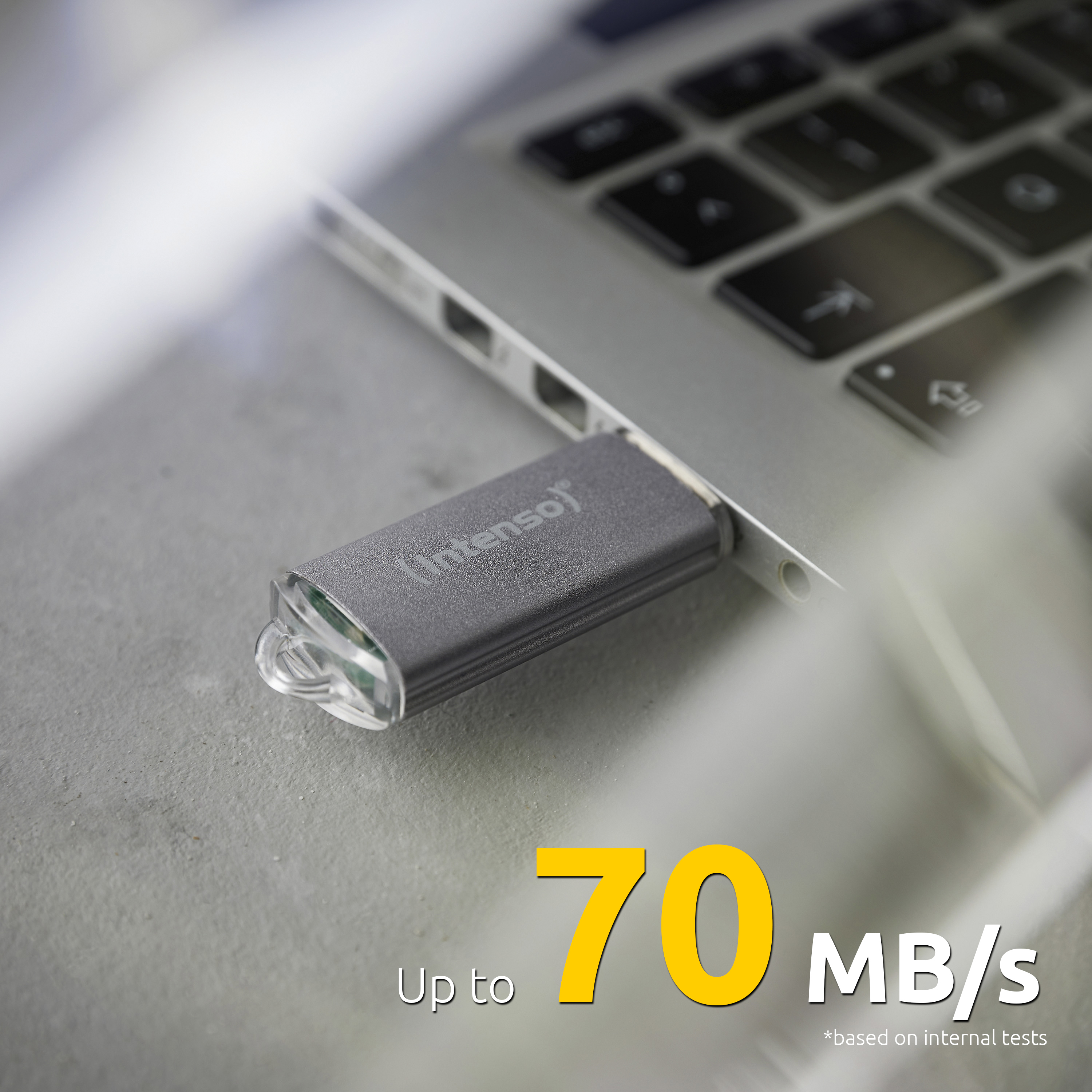 Srebrny dysk USB włożony do laptopa, z tekstem wskazującym jego prędkość transferu danych.