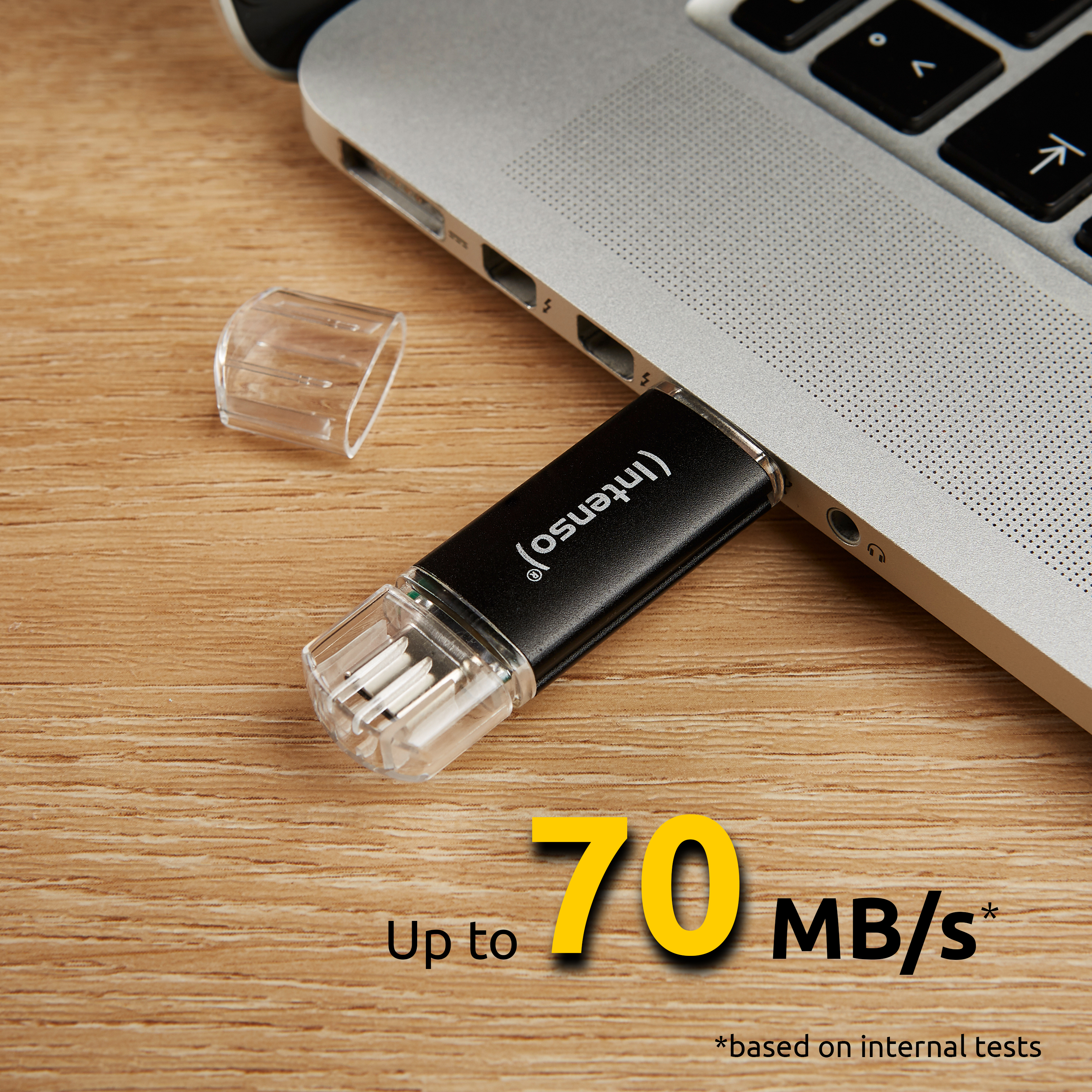 Czarny pendrive podłączony do laptopa, z tekstem '70 MB/s'.