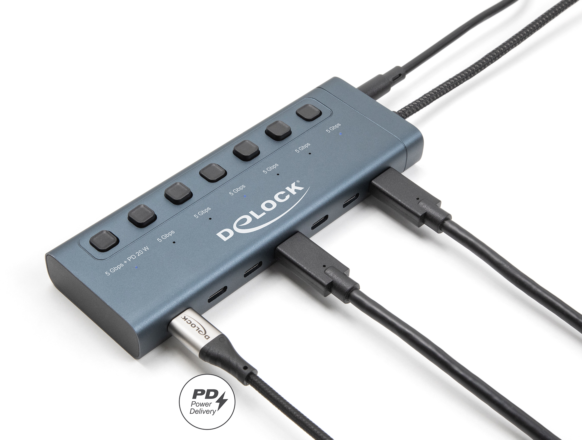 Un hub USB grigio scuro con più porte e cavi USB collegati.