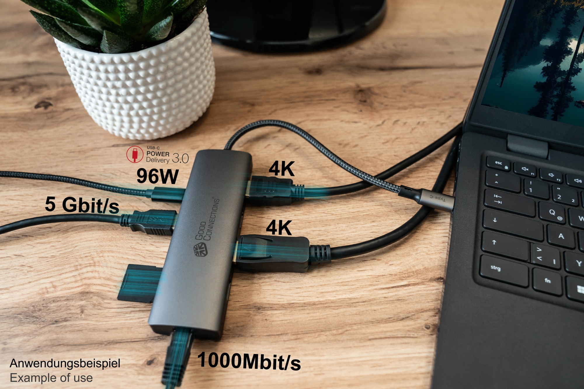 Un hub USB con più cavi collegati a un laptop su una scrivania di legno.