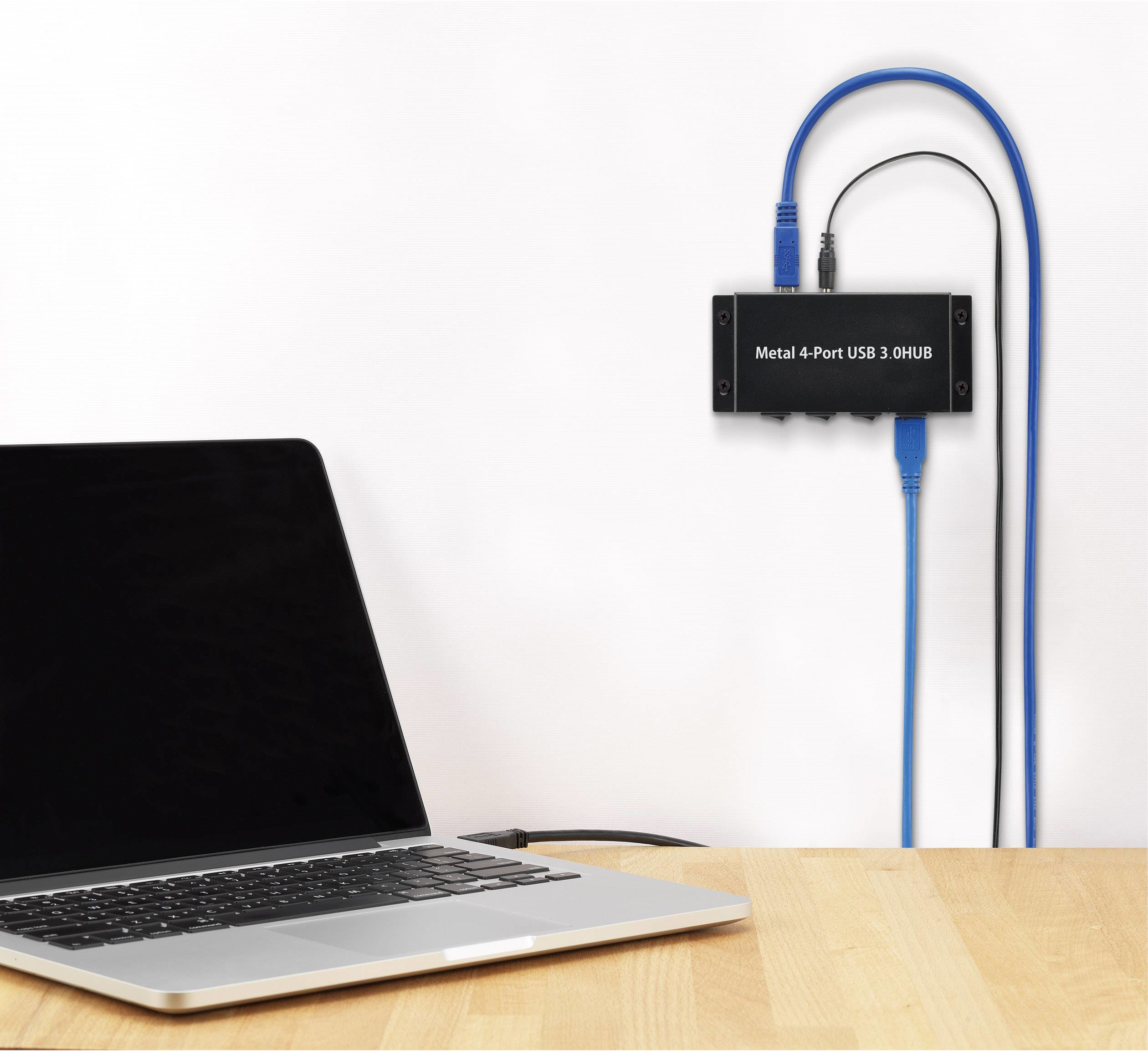 Un hub USB nero collegato a un laptop con cavi blu e neri su una scrivania di legno.