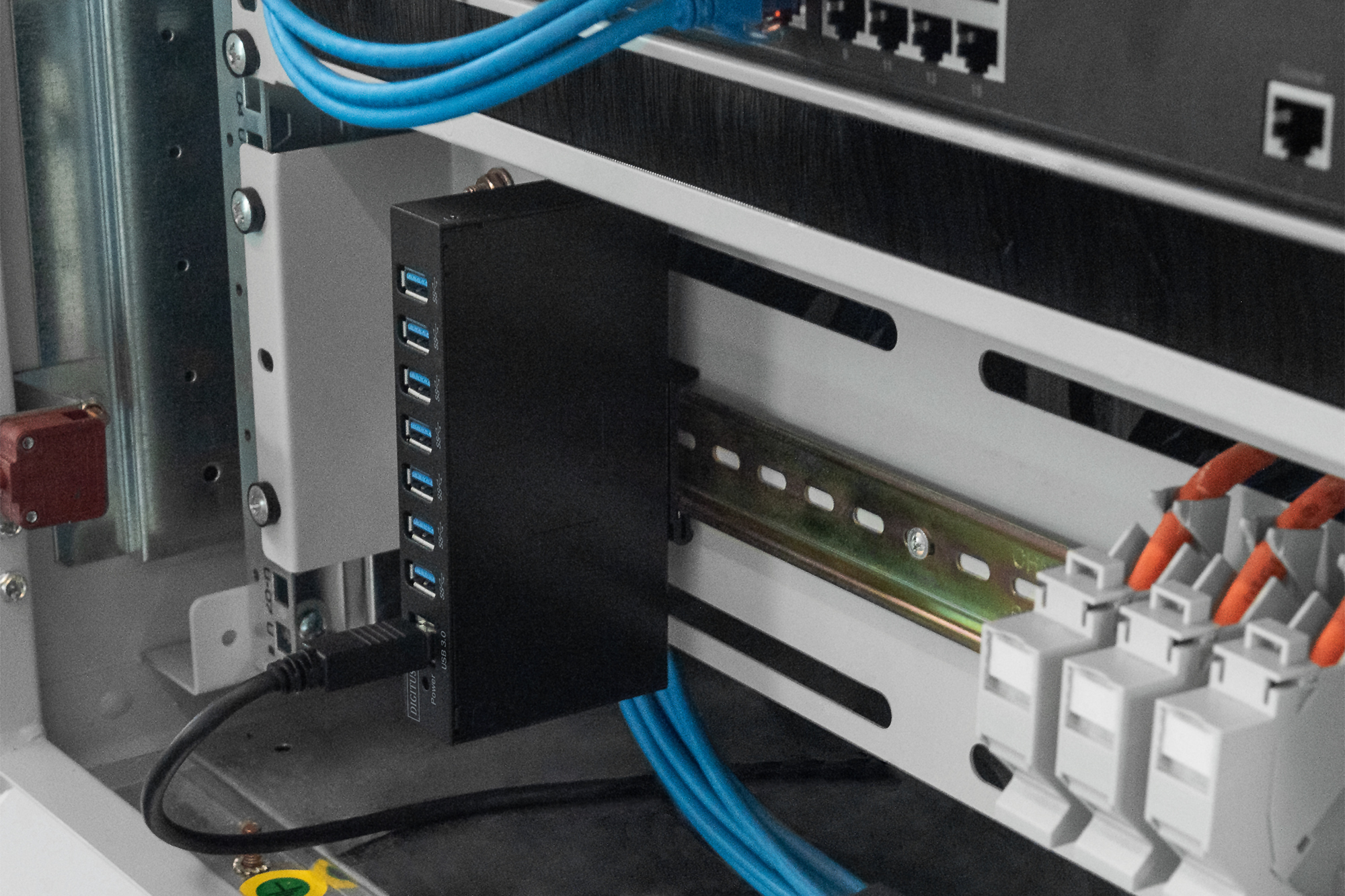 Hub USB nero con porte, cavi e connettori, montato su un rack.