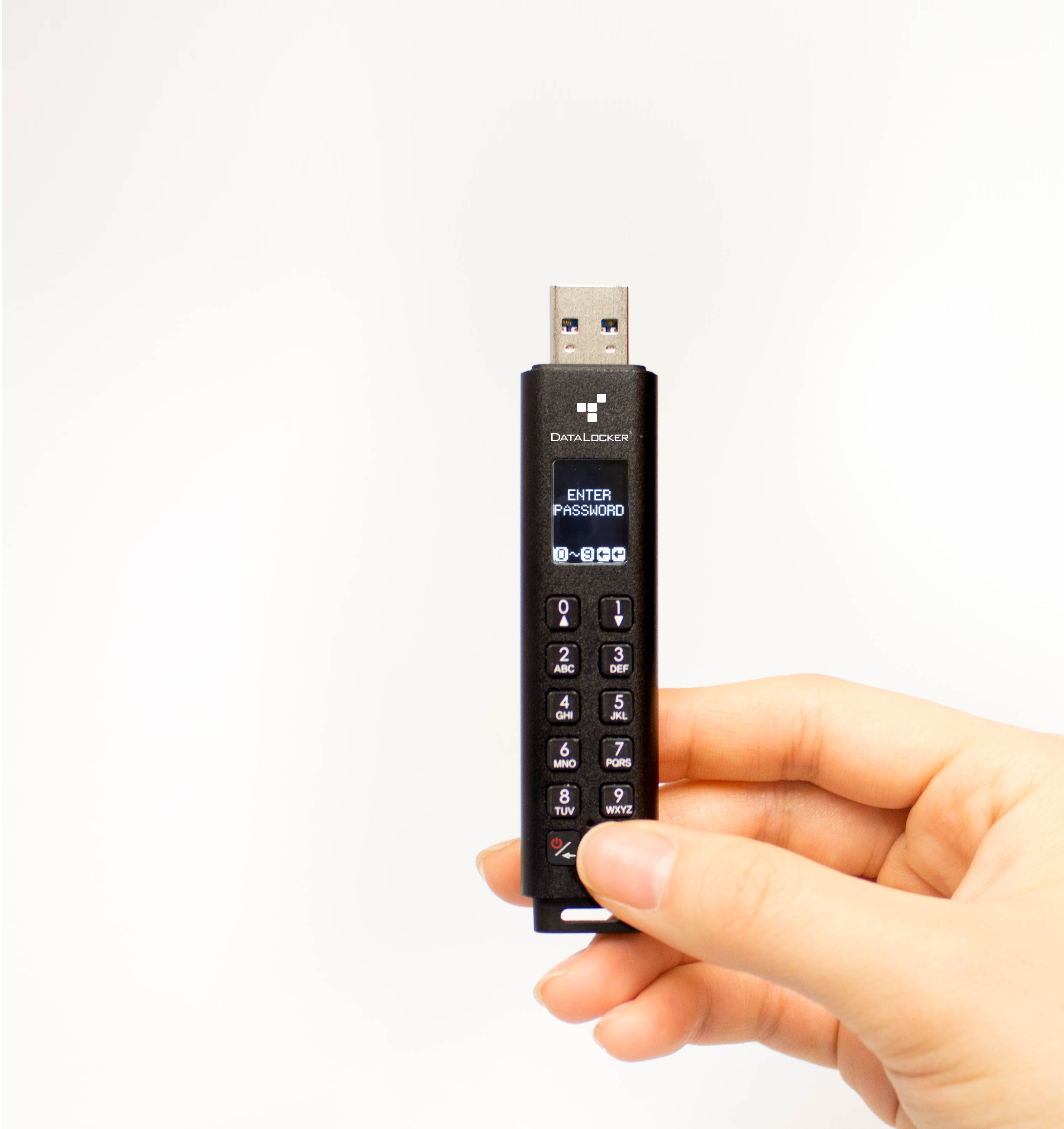 Hand die een zwarte USB-stick vasthoudt met een scherm en numeriek toetsenbord, met 'ENTER PASSWORD'.