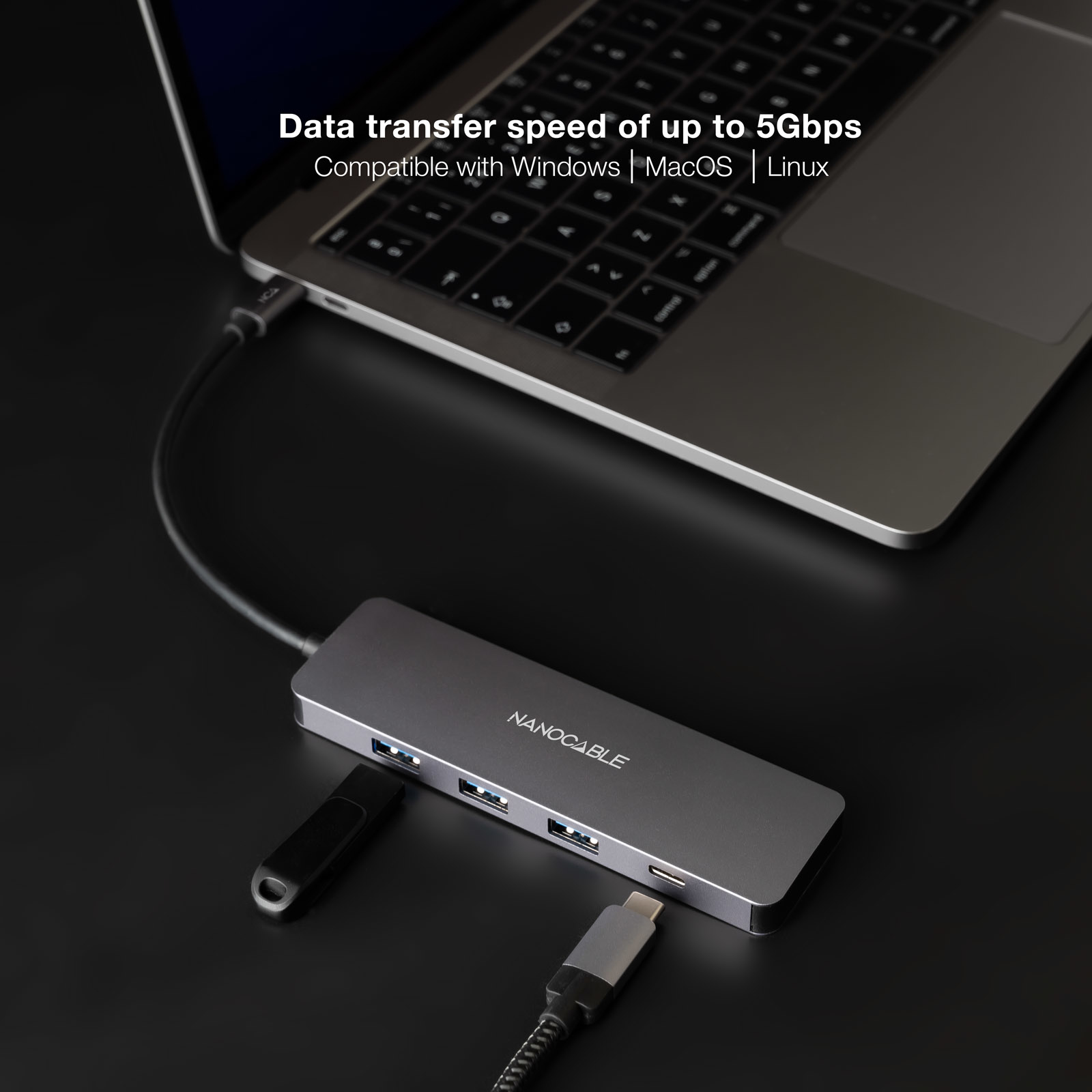 Un hub USB grigio con una chiavetta USB e un laptop.