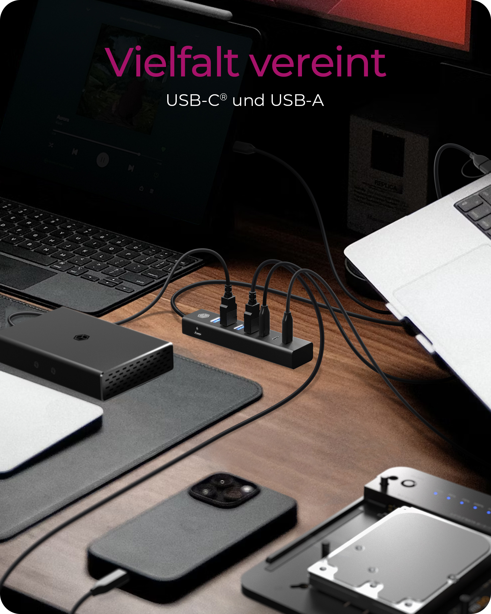 Hub USB che si collega a laptop e dispositivi su una scrivania di legno.