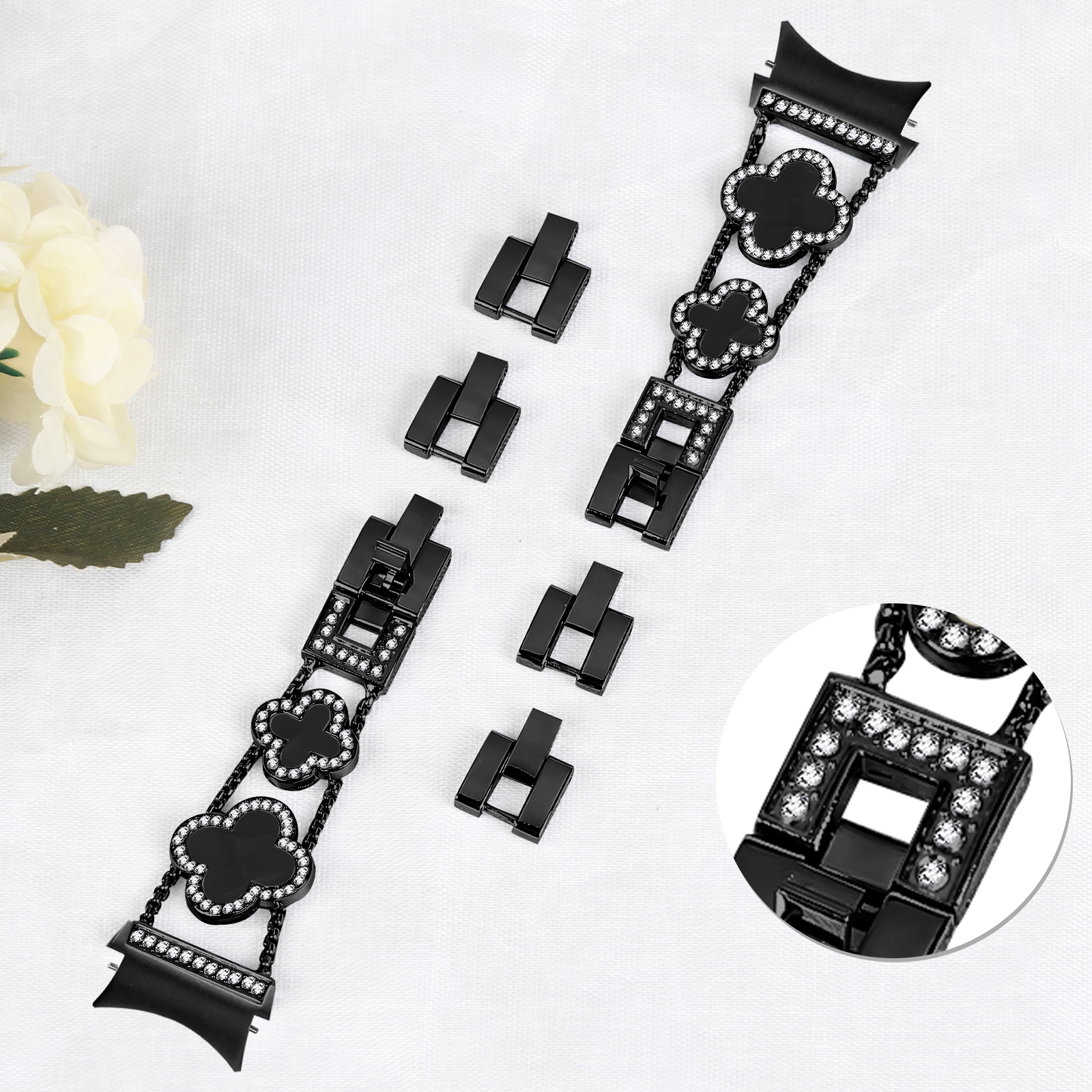 Schwarzes Uhrenarmband mit kleeblattförmigen Gliedern und Verbindern, mit Kristallen.
