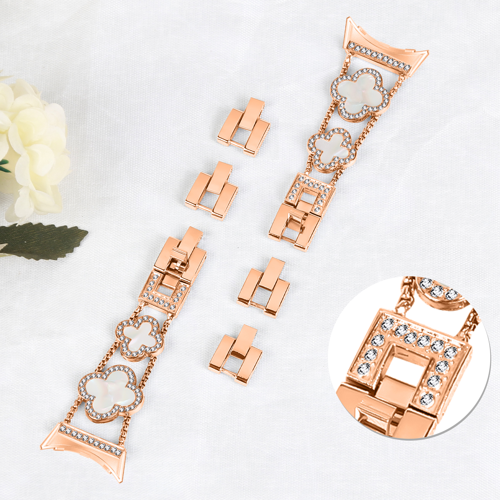 Armband mit Kleeblatt-Akzenten, Gliedern und Verschlüssen. Weißer Hintergrund.