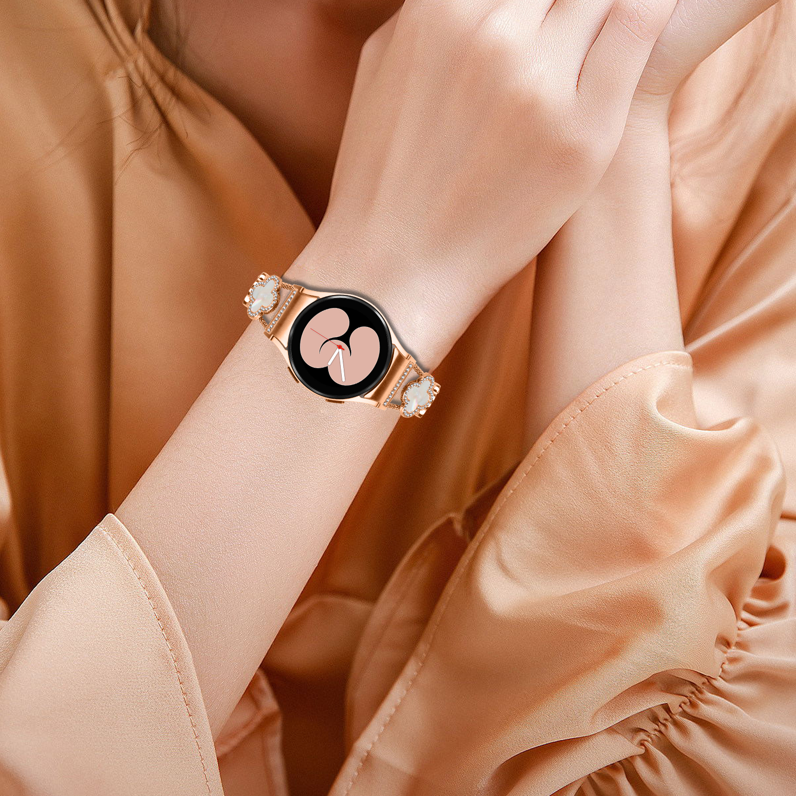 Polso di donna con smartwatch oro rosa e abbellimenti a forma di diamante.