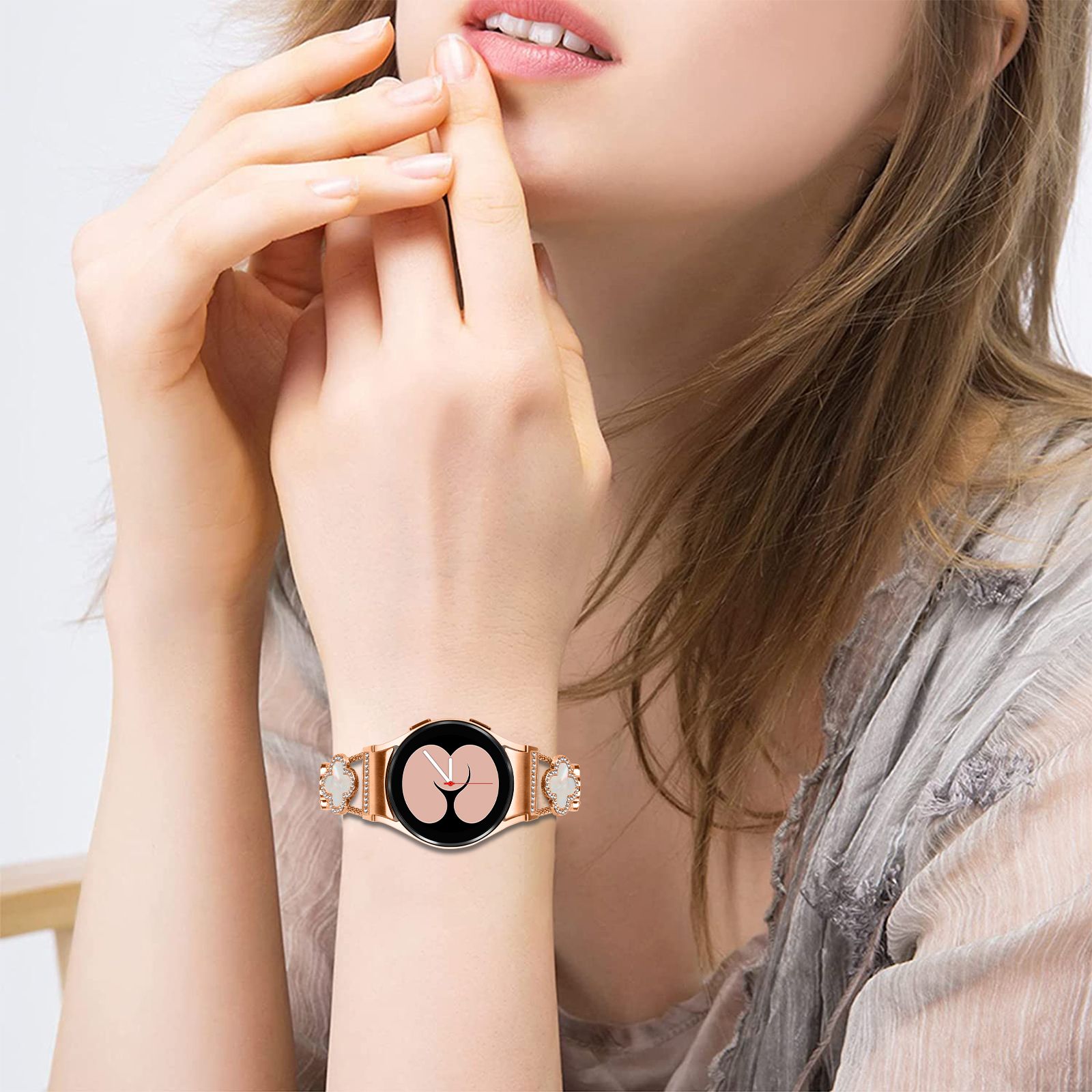 Il polso di una donna con uno smartwatch oro rosa, che mostra il quadrante.
