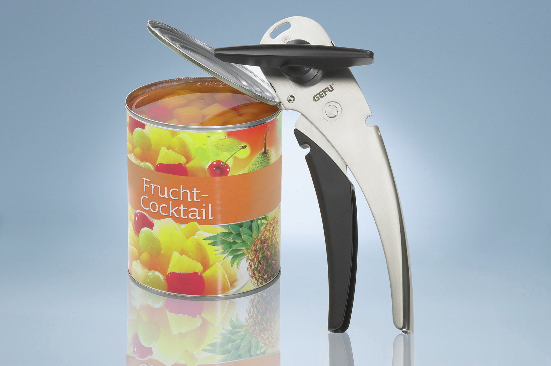 Eine Dose Obstcocktail wird mit einem Dosenöffner geöffnet. Die Dose ist orange und hat Text.