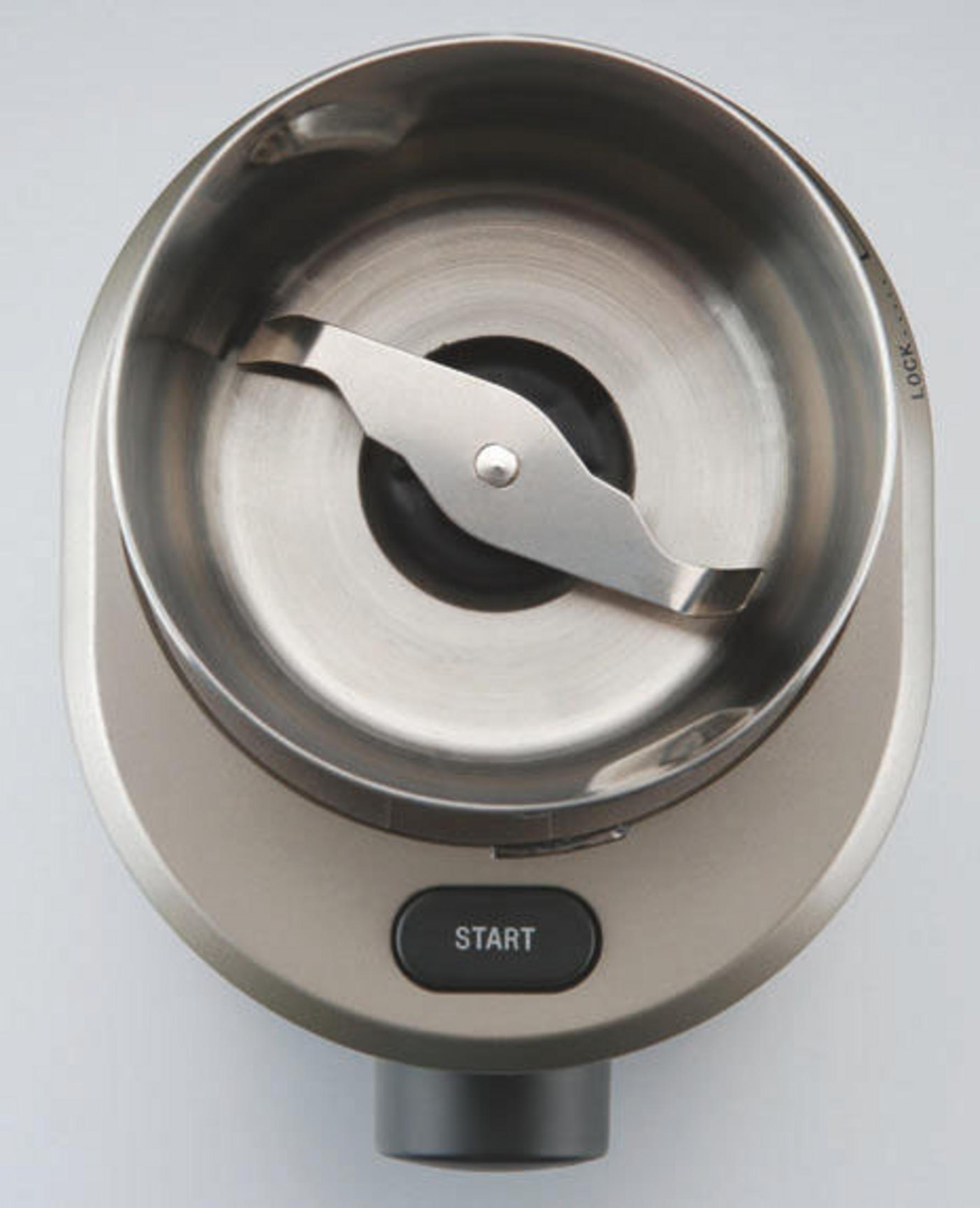 Zbliżenie młynka do kawy. Widoczne ostrze mielące i przycisk start.