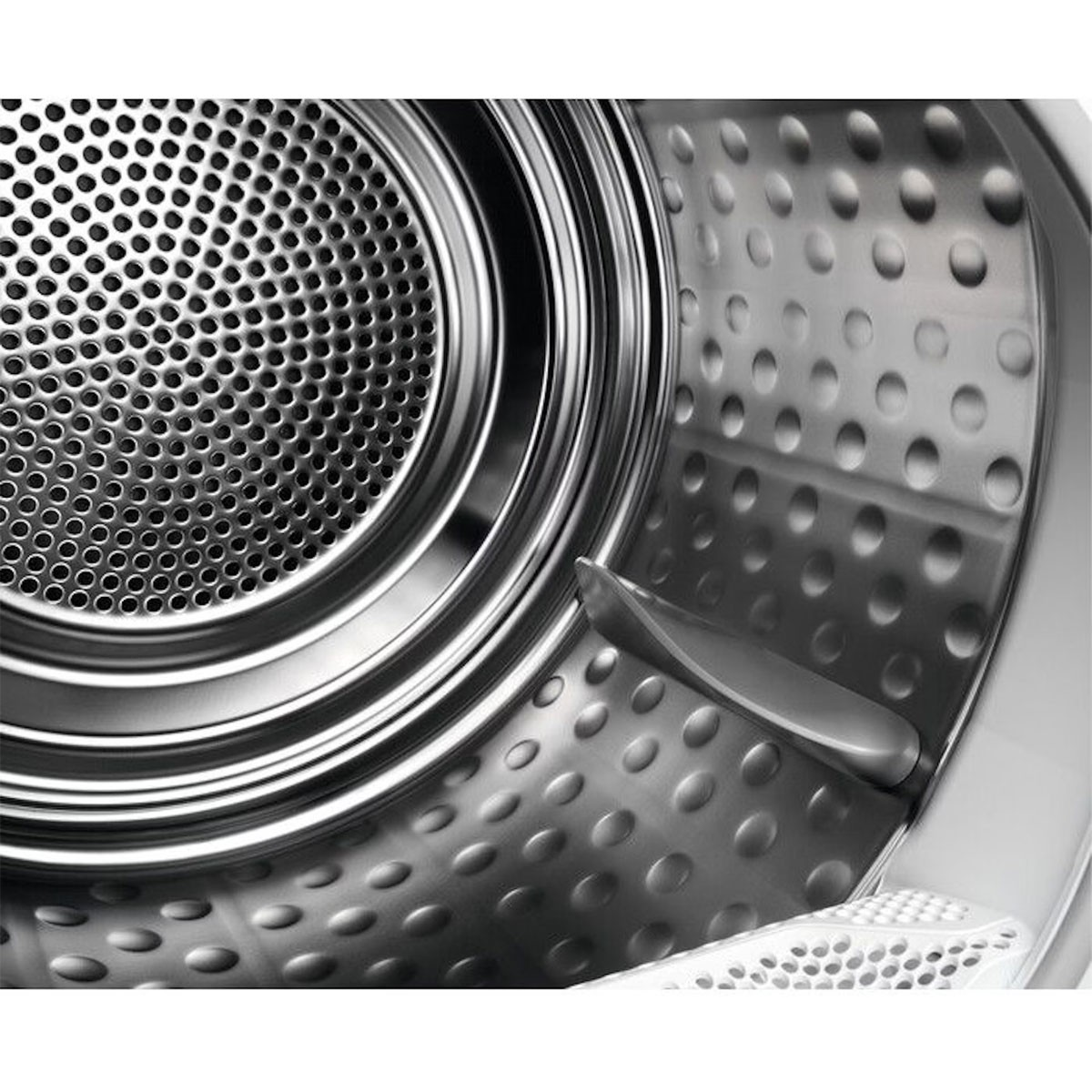 Close-up of a washing machine drum interior, with perforated metal. Silver color.